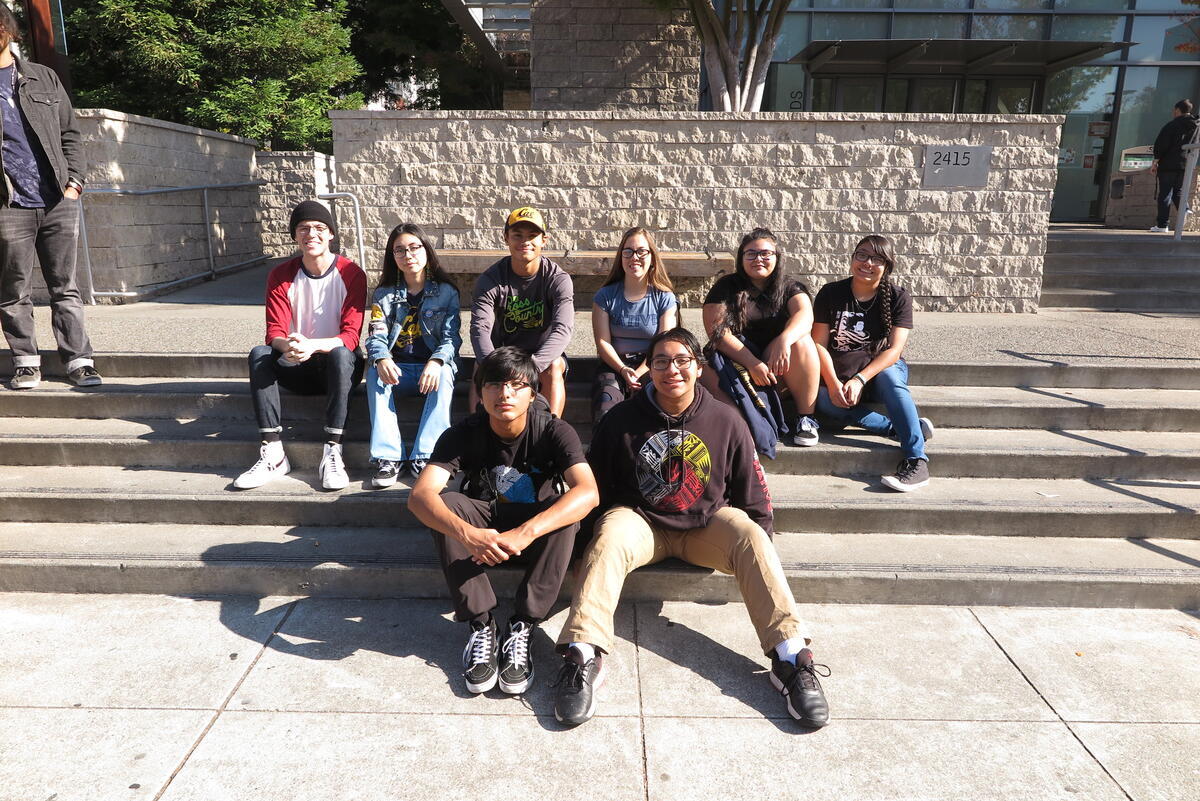 [Image] Students smiling at the camera posing on a staircase