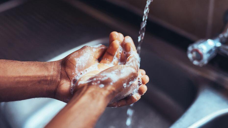 Person washing their hands that are soaped up