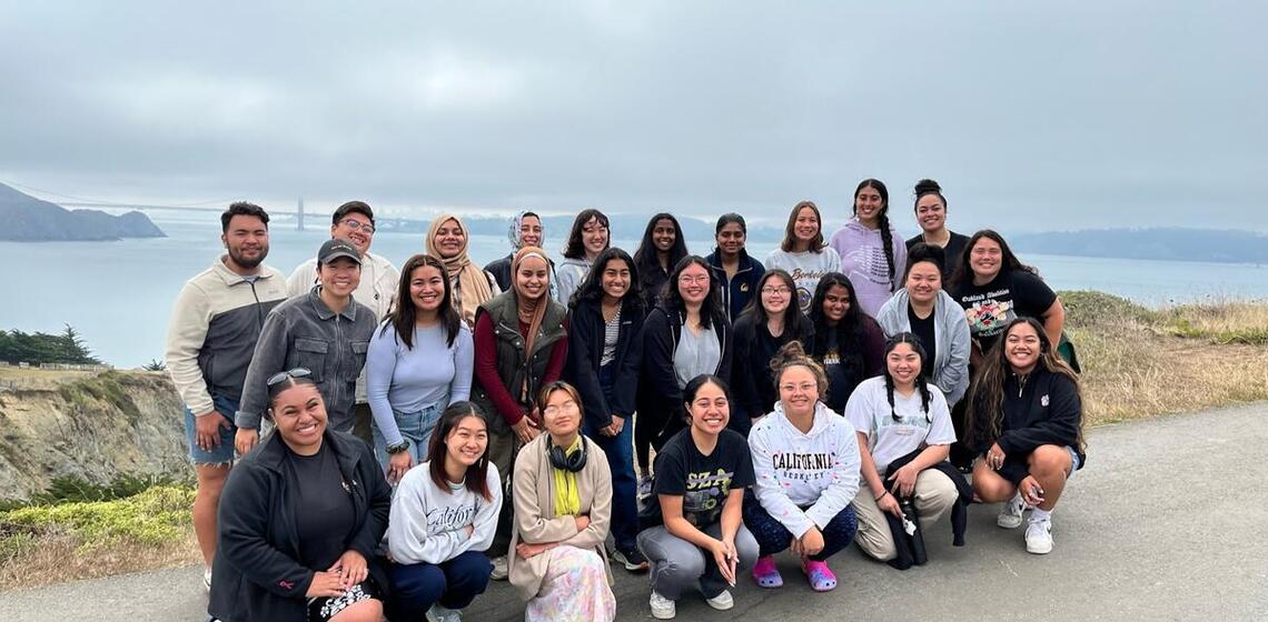 Group Photo of 30 people in Marin Headlands wth golden gate Bridge behind them
