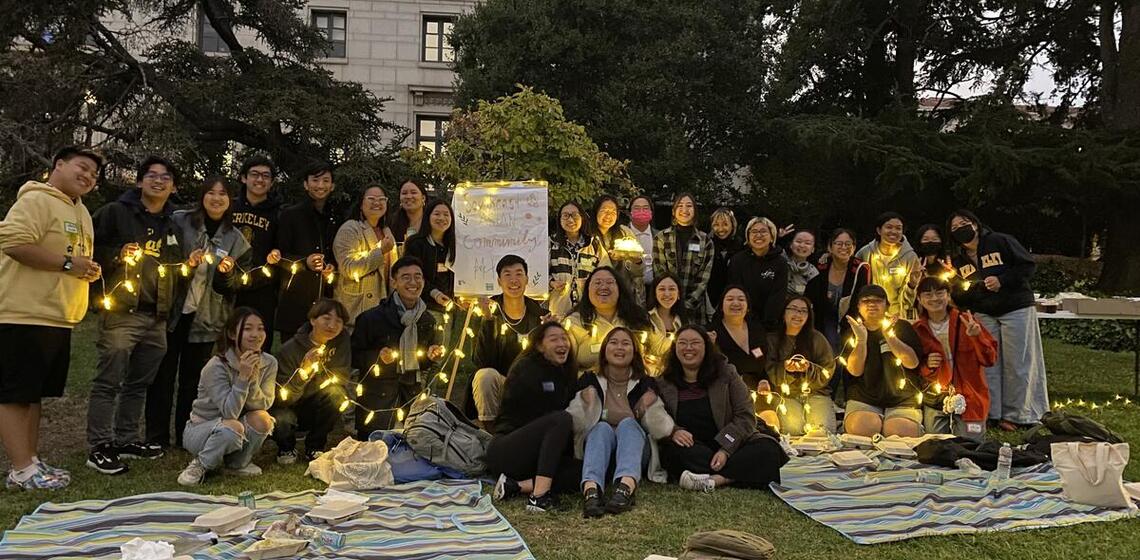 Photo of students on lawn holding lights
