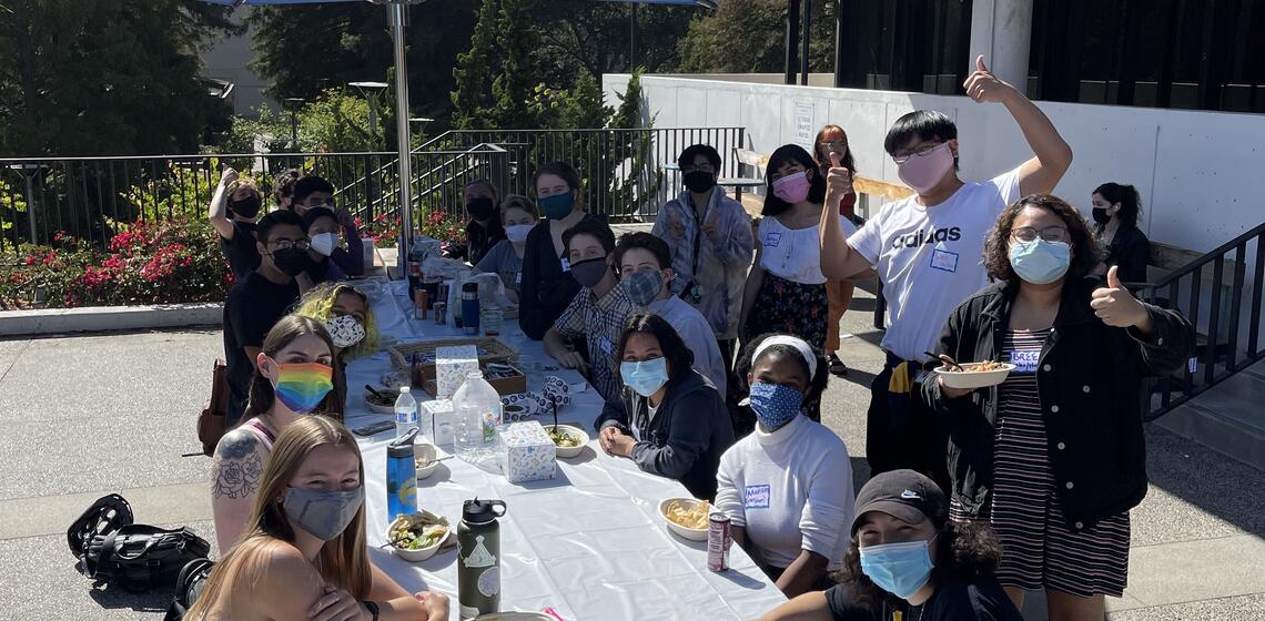 Queer Cal Pals and Buddies sit outside GenEq for a social